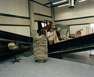 800704 Afbeelding van enkele medewerkers bij de stortband voor pakjes in het Kantoor Postdistrict Utrecht van de P.T.T. ...
